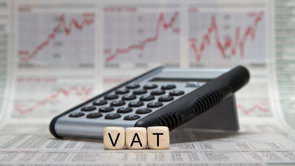 Calculator de birou și cuburi cu literele VAT, pe pagini cu grafice financiare
